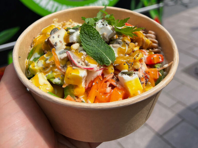 Eine Person hält einen Pappbecher mit einem Salat darin von Monkey Soup Hamburg